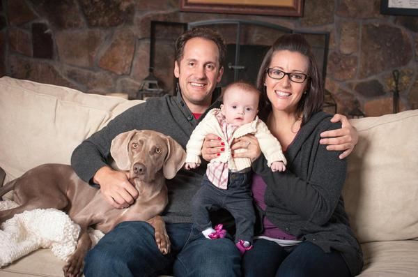 Thomas and Noel Rademacher pose in family photo with 5-month-old Charlotte and pet Weimaraner.