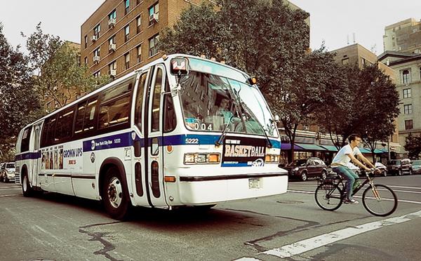 Bus and bike shown on a city street illustrating alternative modes of transportation.