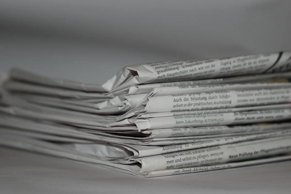 stack of folded newspapers against white background