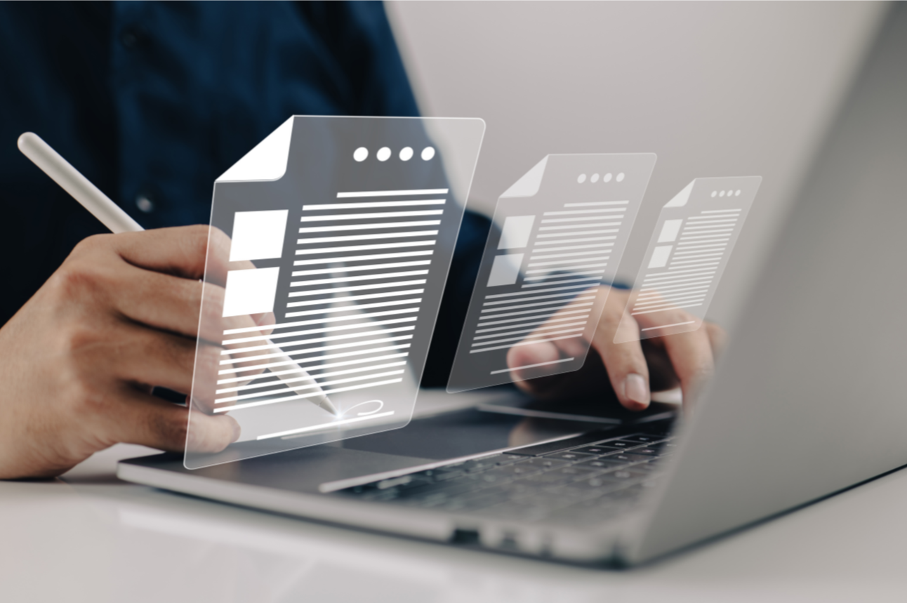 Person working on laptop with reflection of documents popping up from screen Person working on laptop with reflection of documents popping up from screen