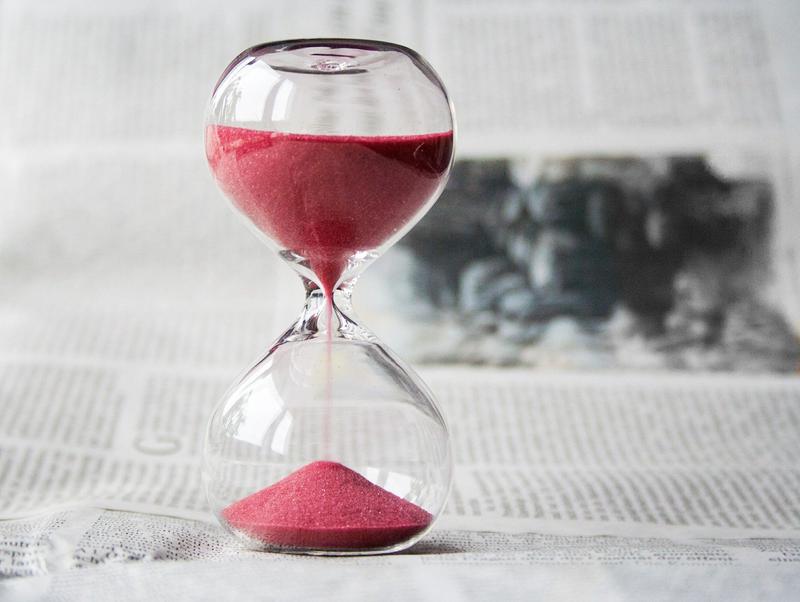 An hourglass on top of a newspaper