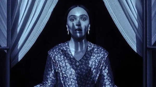 A still from the movie Nosferatu (2024), showing a shadowy hand over Ellen's face.
