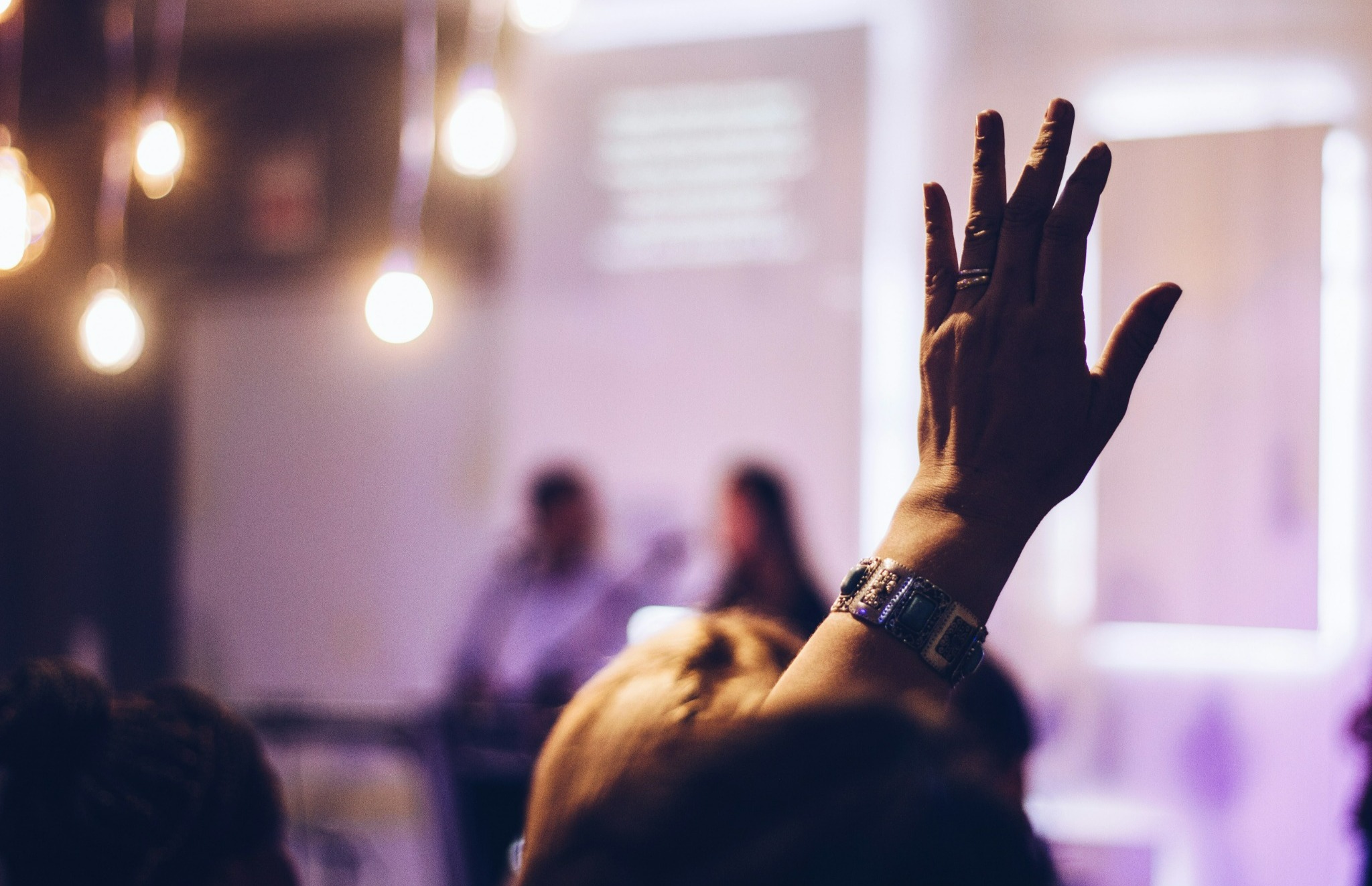 Person raising hand to ask a question