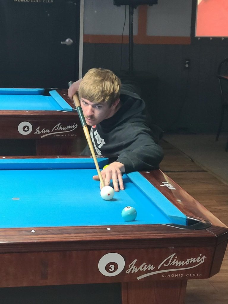 E-STAND trial participant, Evan Faucett playing his new favorite competitive sport, pool. E-STAND trial participant, Evan Faucett playing his new favorite competitive sport, pool.