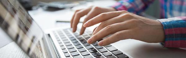 man typing on laptop