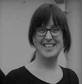 Black and white photo of dark haired woman in glasses smiling