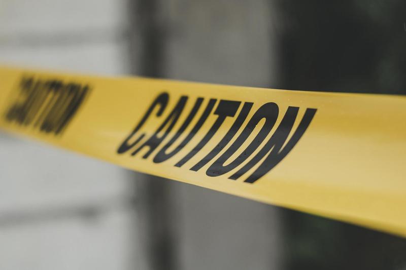 A yellow CAUTION tape is seen outside.