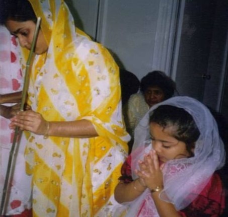 A photo from Krystal's childhood is seen, in which, Krystal's bowed covered head and clasped hands are seen, while her beloved aunt stands beside her in yellow, holding a bamboo stick, with which, she participates in a Hindu ritual, while Ruby, Krystal's maternal grandmother is seated behind them, in her aunt's home in NYC.