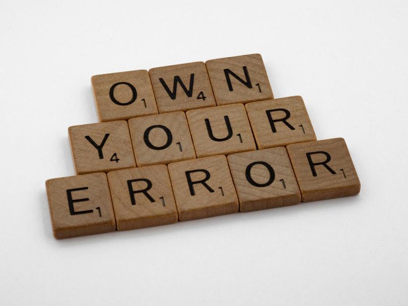 Against a cream background, brown letter tiles state: OWN YOUR ERROR