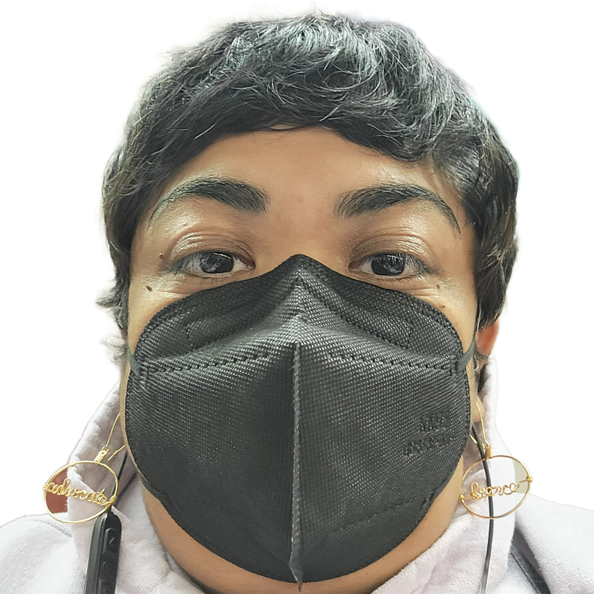 A selfie of Krystal Kavita Jagoo, a fat brown queer disabled immigrant woman and settler on Turtle Island, is seen. She is wearing a black KN95 mask, gold earrings that state "fierce" & "advocate," and a lavender hoodie. She has a black pixie cut, and black earphones.