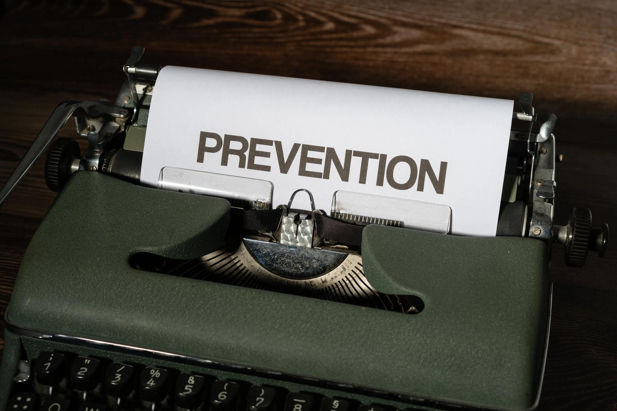 A typewriter is seen, in which, a white sheet of paper has "PREVENTION" stated in black capital letters.