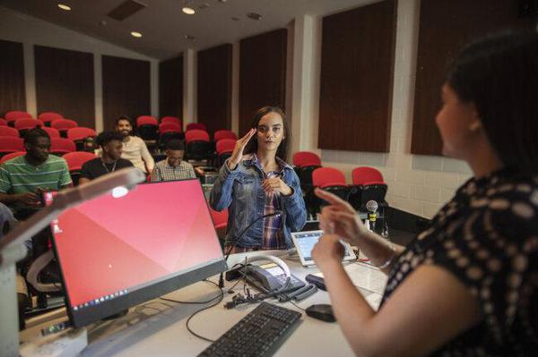 A student in class using sign language to communicate with the instructor.