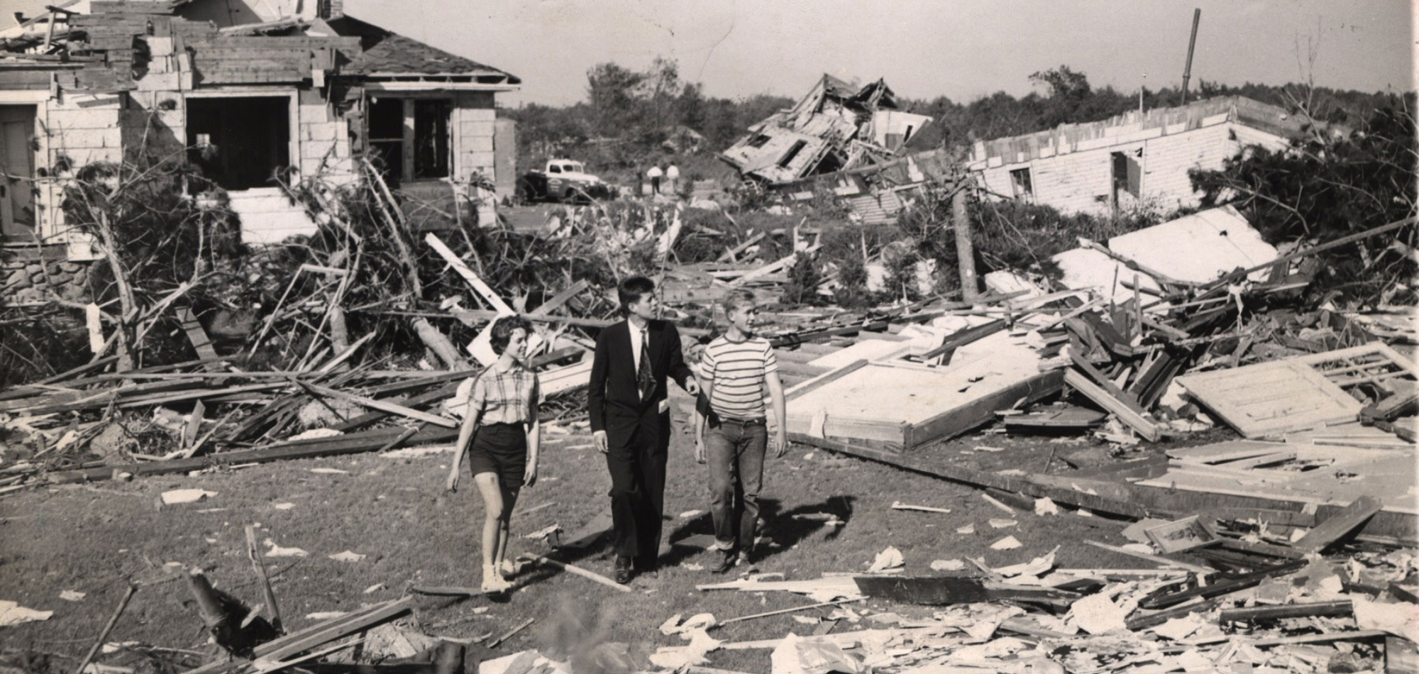 Photo of young Massachusetts Senator John F. Kennedy surveying the damage in Worcester.