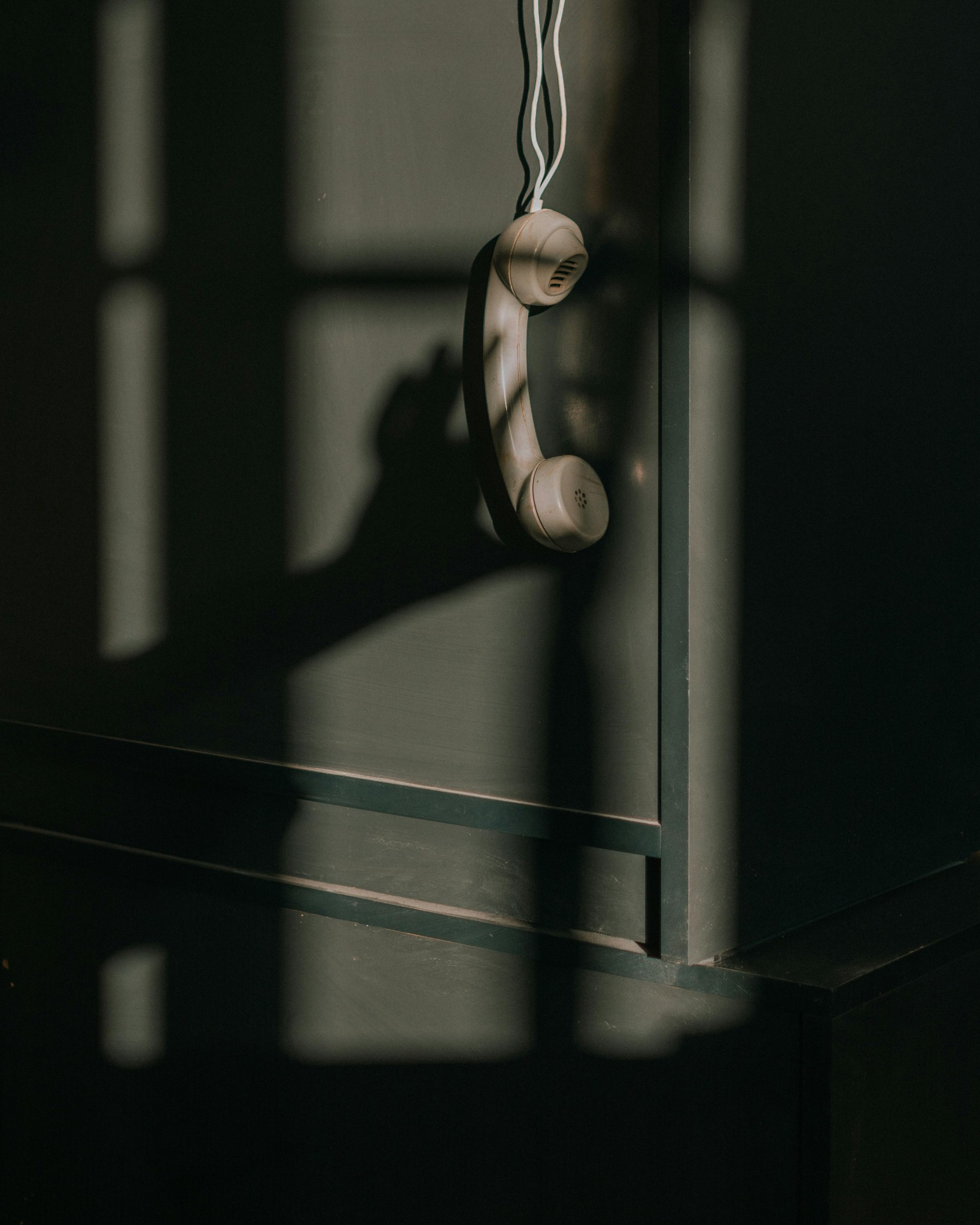 a phone receiver hanging down the shelf