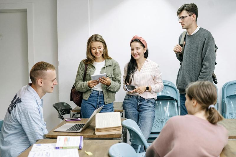 University students gather around an open laptop and books.