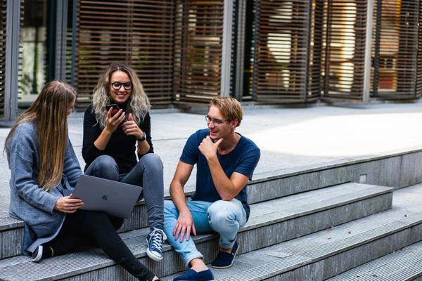 College students hang out around a laptop.