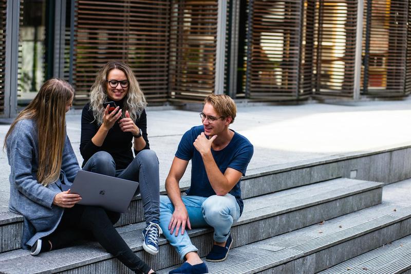 College students hang out around a laptop. College students hang out around a laptop.