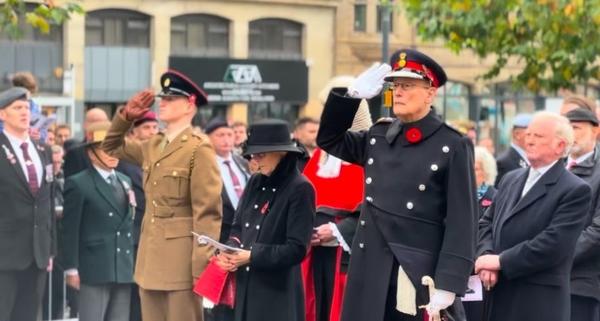 In this image the Lord Lieutenant is saluting to the war memorial in Victoria Gardens as people look on