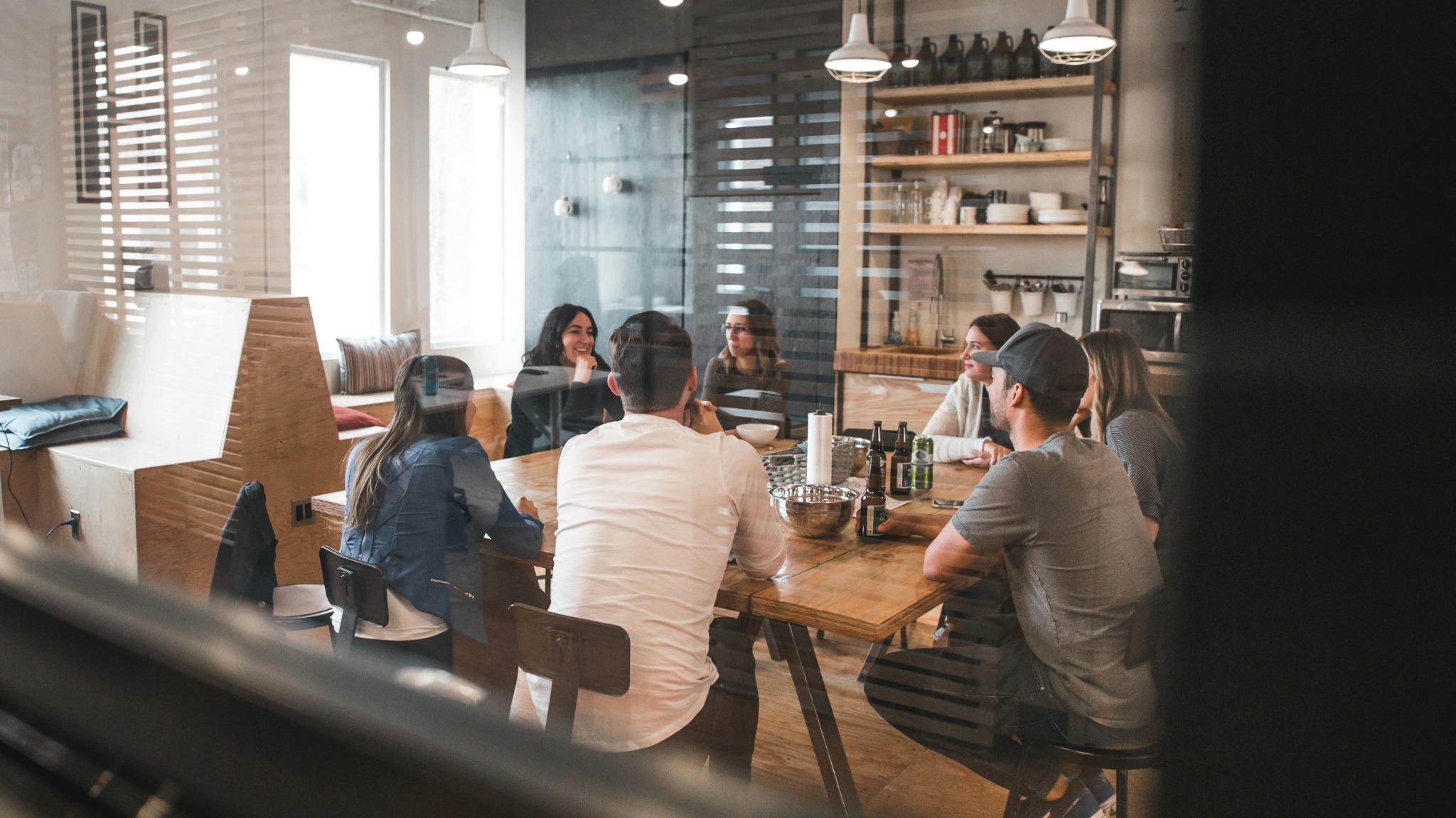 groupe des personnes qui sont assis autour d'une table dans un bureau et qui discutent