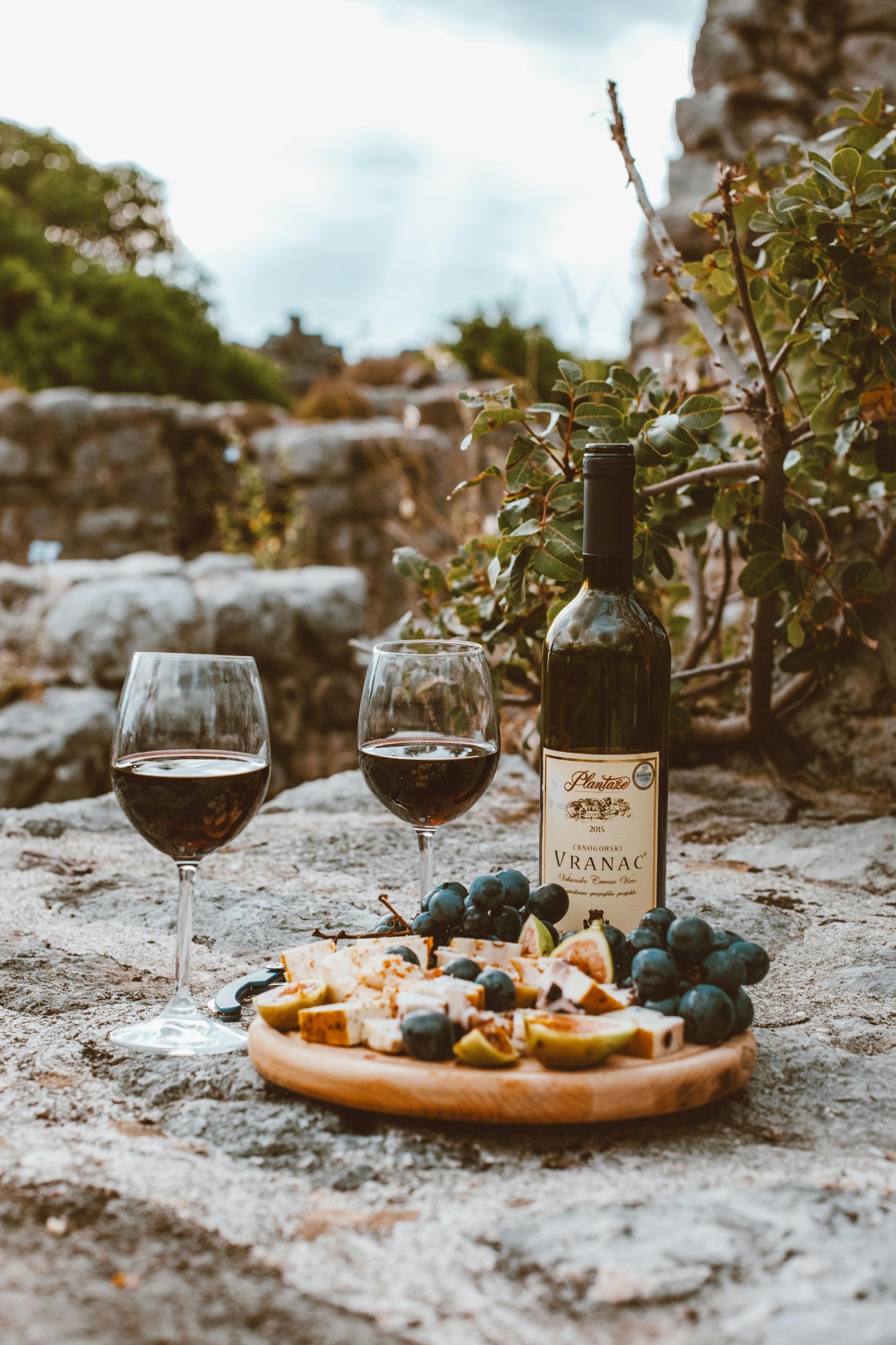 plateau de fruits devant 2 verres de vin et une bouteille de vin de Vranac