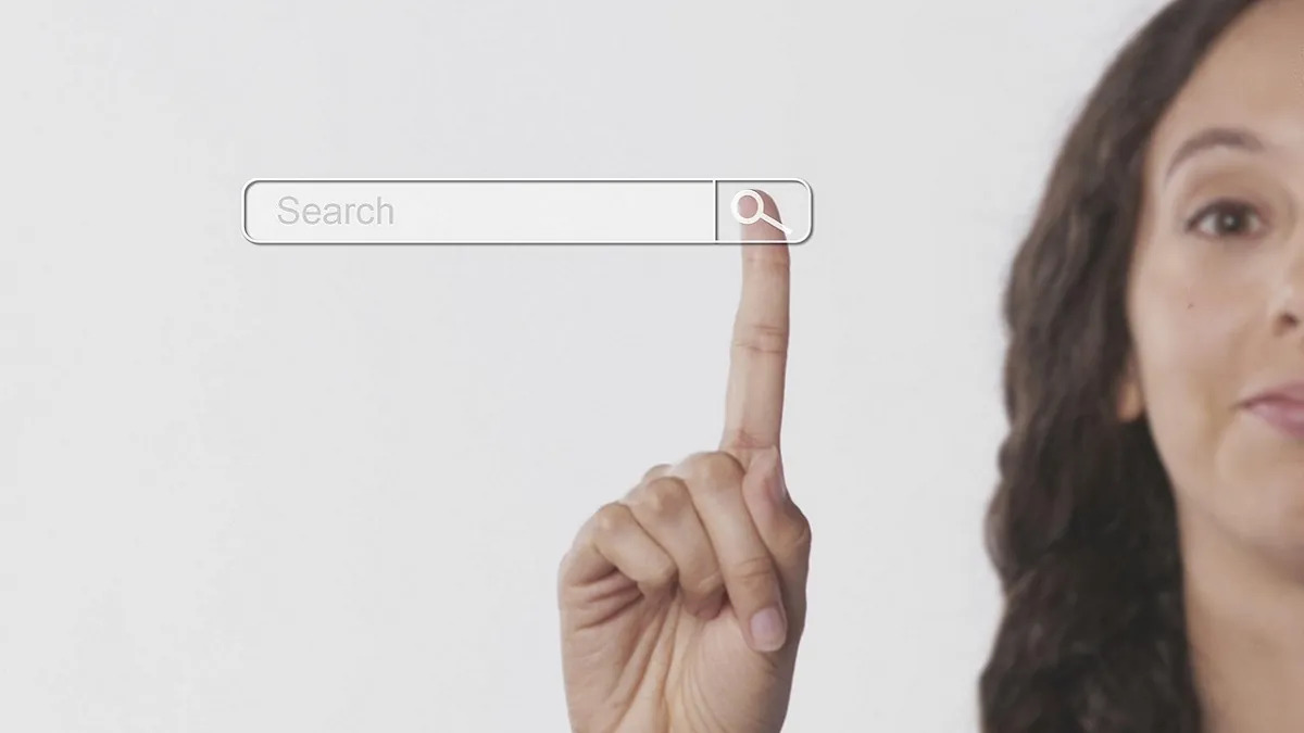 A photo of a caucasian woman pressing her finger on a search button.