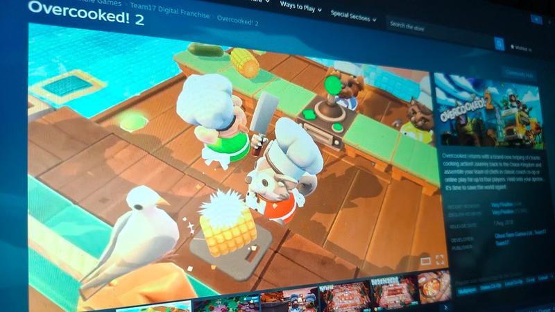 A close-up screenshot of the Steam page for Overcooked 2, showing a bright image from the game.