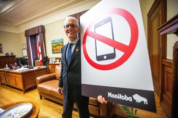Nello Altomare holds up a sign celebrating the new cell phone ban
