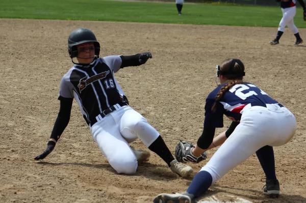 A softball player slides into an out