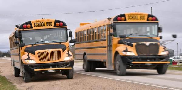 A school bus drives by another school bus