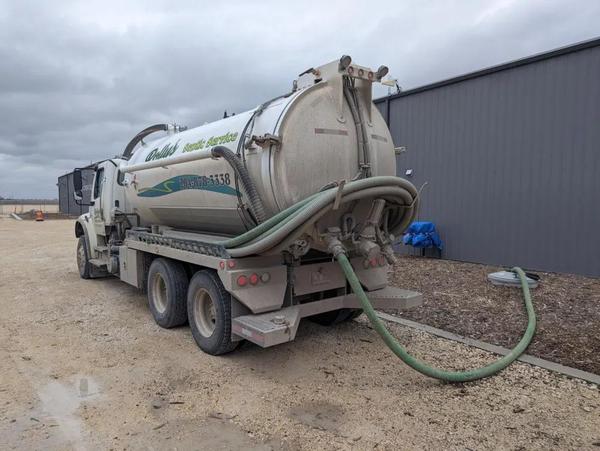 A septic service truck removes sewage from underground