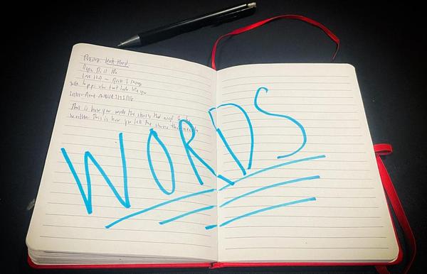 A journal spread with the word "WORDS" written in blue marker in capital letters.