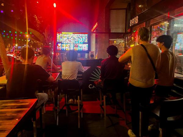 Six Beaches patrons play Nintendo Smash Bros. at night.