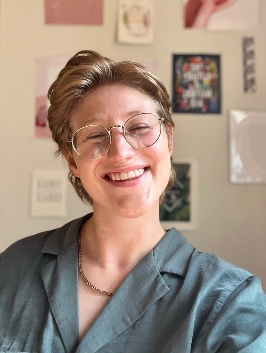 Pictured: Brooks is a white person with short blonde hair and gold wire-rimmed glasses, smiling and wearing a gold chain and teal button down shirt Pictured: Brooks is a white person with short blonde hair and gold wire-rimmed glasses, smiling and wearing a gold chain and teal button down shirt