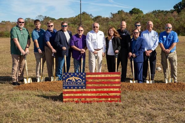 A group of city staff, the mayor, and councilmembers stand in a row with shovels during the Seabrook PGWWTP groundbreaking ceremony in December 2021.