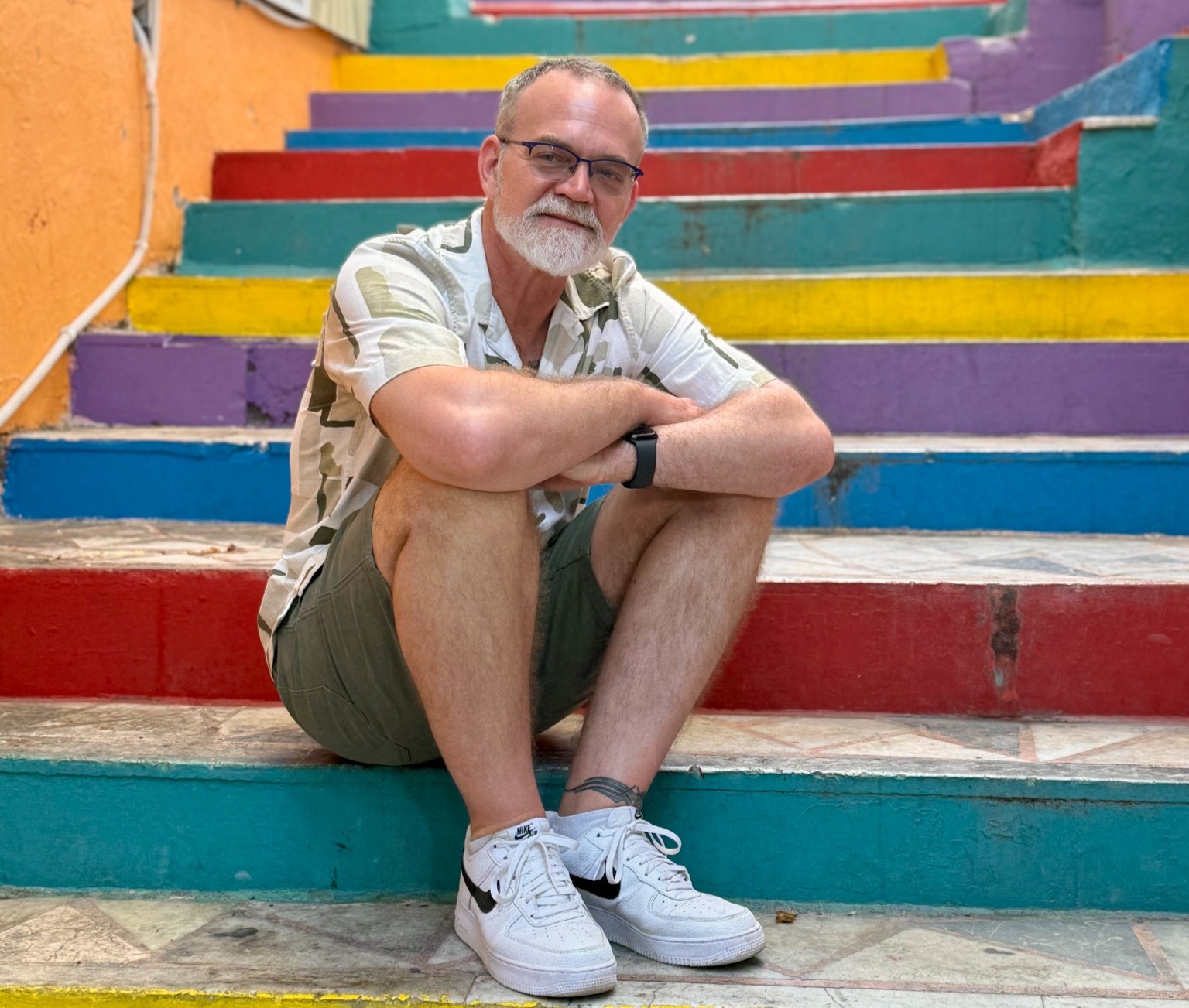 Bil Browning sits on colorful stairs