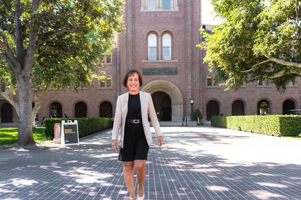 A Daily Trojan file photo of USC President Carol Folt, walking outside of the Bovard Auditorium.