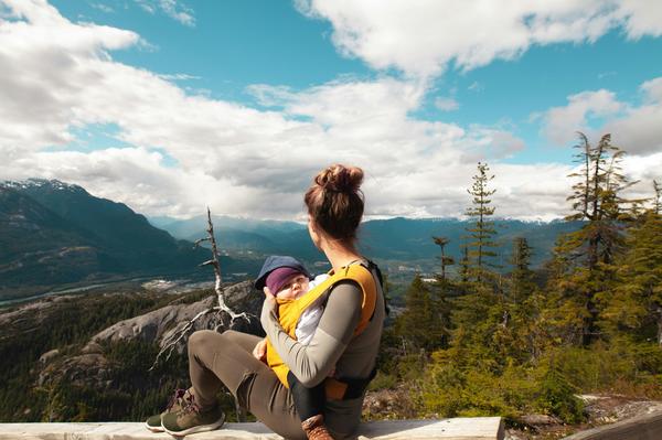 Mom with newborn looking out over a mountain vista