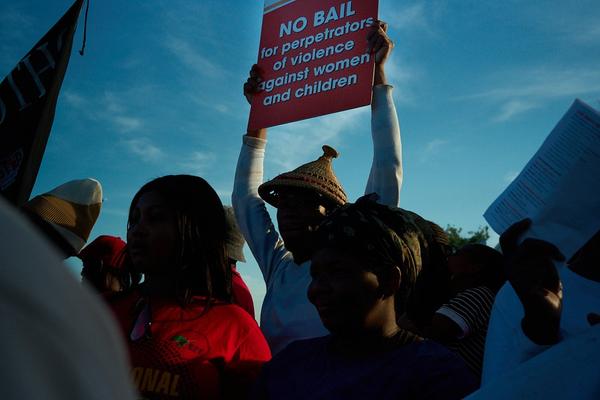 protesters at the march on 25 November 2025, holding a protest sign