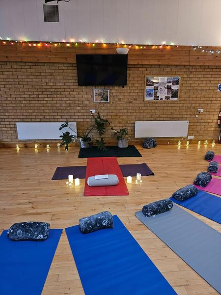 A professionally prepared yoga studio at Daisy Chain Yoga featuring color-coded mats, cosy blankets, and warm fairy lights.