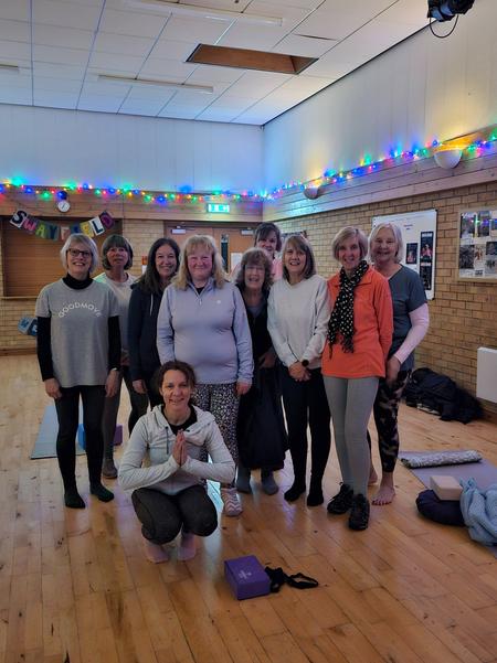 A smiling group of yoga students at Swayfield Village Hall with Daisy Chain Yoga, highlighting the welcoming community atmosphere.