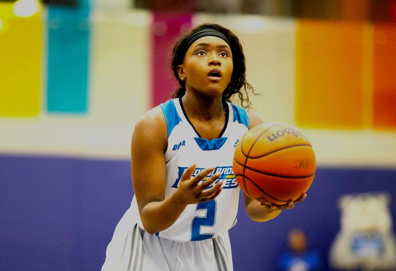 A young woman with a basketball about to make a free throw.