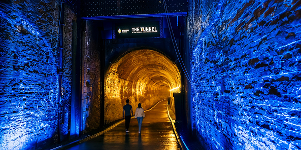 Two people entering the tunnel at the power station.