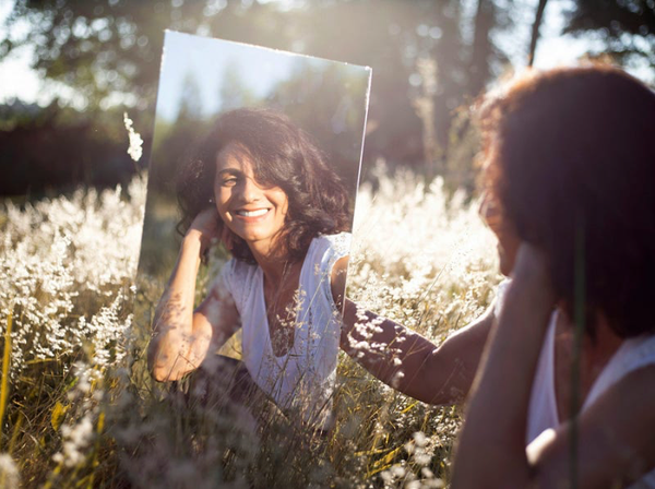woman looking at her reflection in the mirror