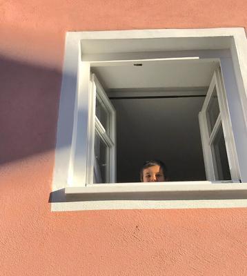 child peeking out window