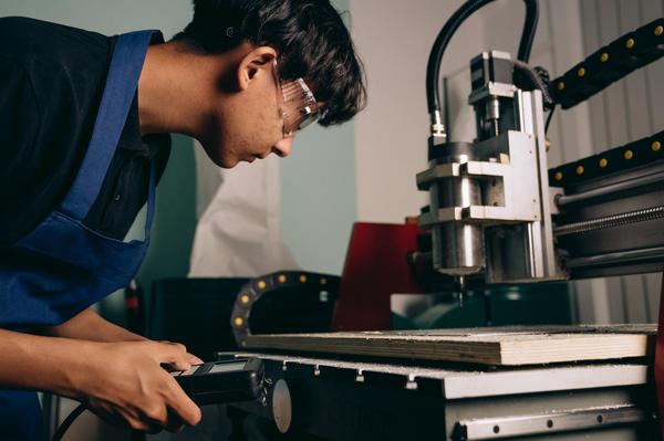 An apprentice working with machinery in an engineering workshop.