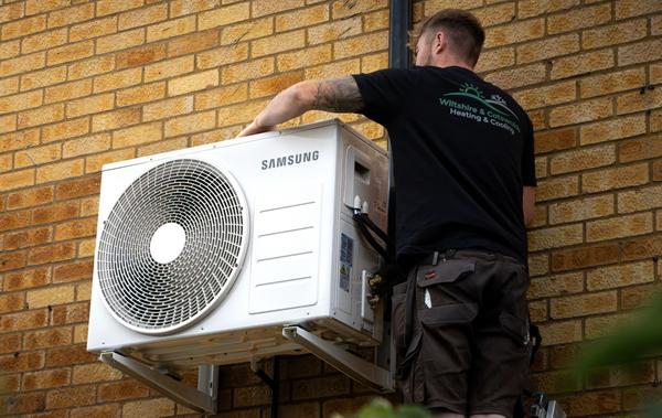 Wiltshire & Cotswold Heating and Cooling employee working on AC. Photographed by Lowes Creative Media