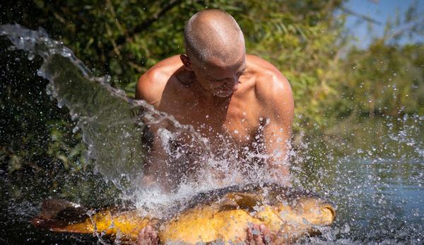 Man Celebrating fishing personal best. Man holding fish. Photographed by Lowes Creative Media