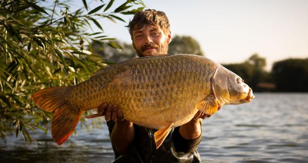 Owner of Solid Angling Solutions. Jared holding Carp Fish. Photographed by Lowes Creative Media