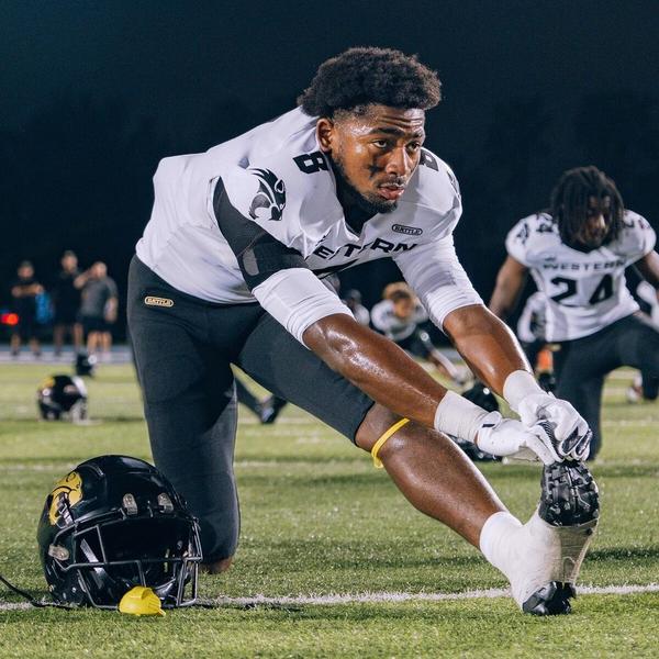 A football player applying tape to his cleats A football player applying tape to his cleats