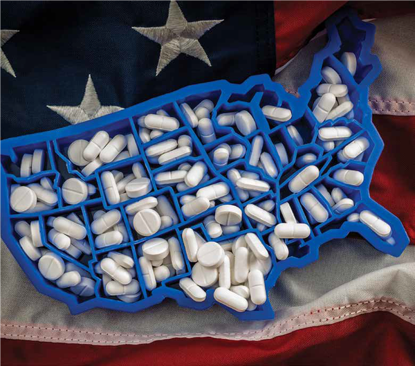 A pill holder shaped like America on top of an American flag A pill holder shaped like America on top of an American flag